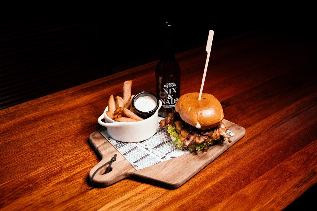 Burger med pommes frites og øl på trefjøl